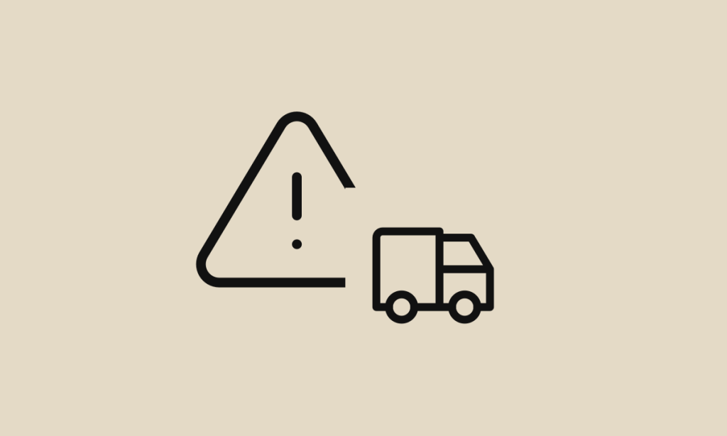 Ícones de alerta e caminhão sobre fundo areia